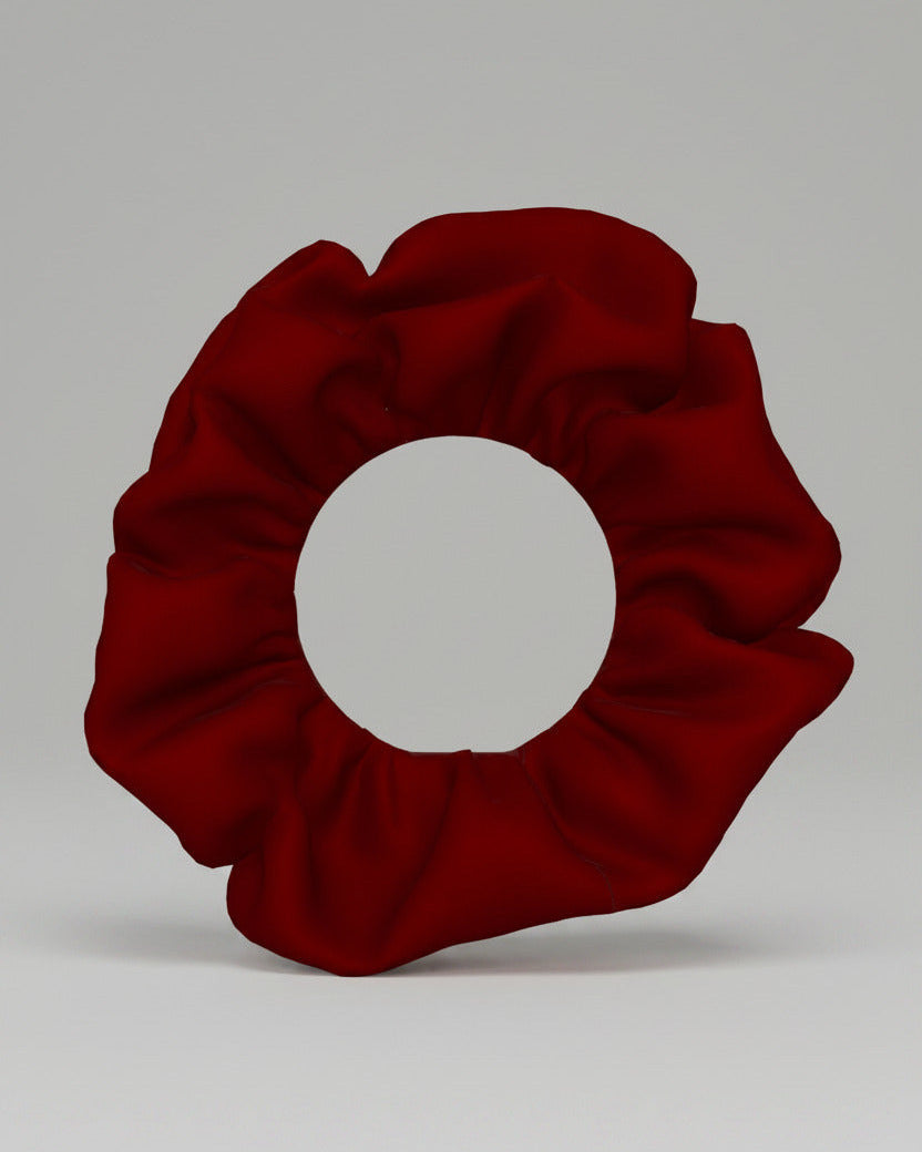 A single dark red fabric scrunchie shown from a top-down view on a plain white background.