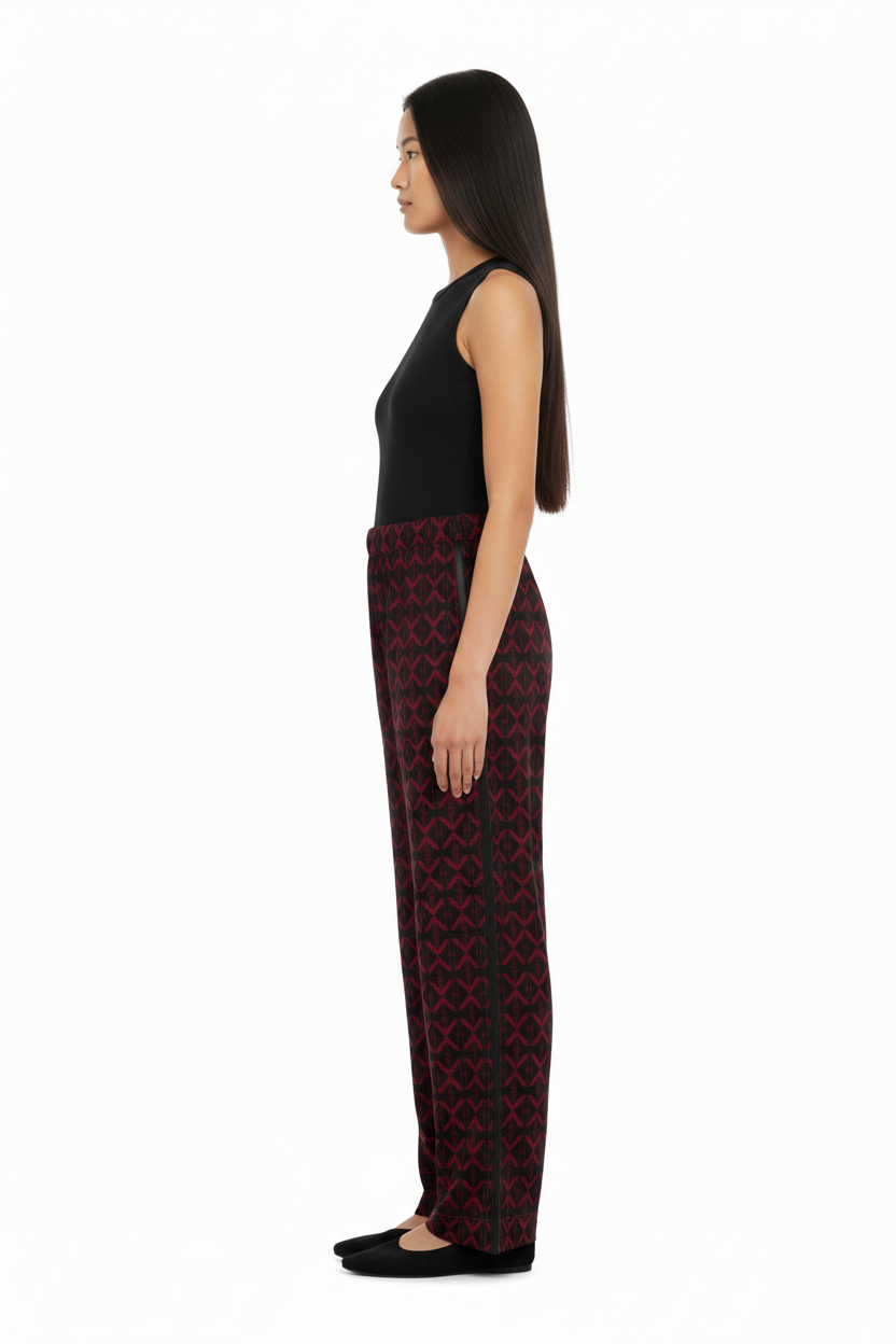 Side view of a model wearing NIMIAN Luxury Pyjama Trousers with a red geometric pattern