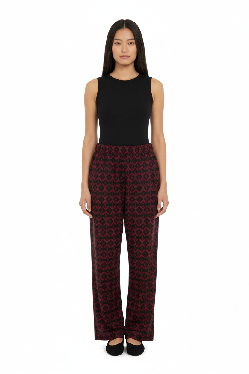 Front view of a model wearing NIMIAN Luxury Pyjama Trousers with a red geometric pattern