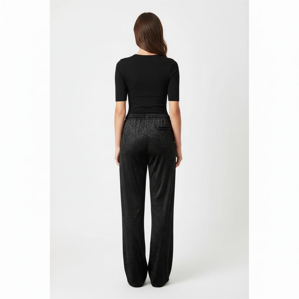 Female model wearing NIMIAN women's black crushed velour wide-leg trousers, clean back view