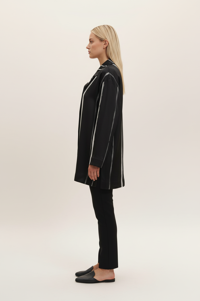 Side view of a model wearing the NIMIAN Nocturna striped silk pyjama shirt