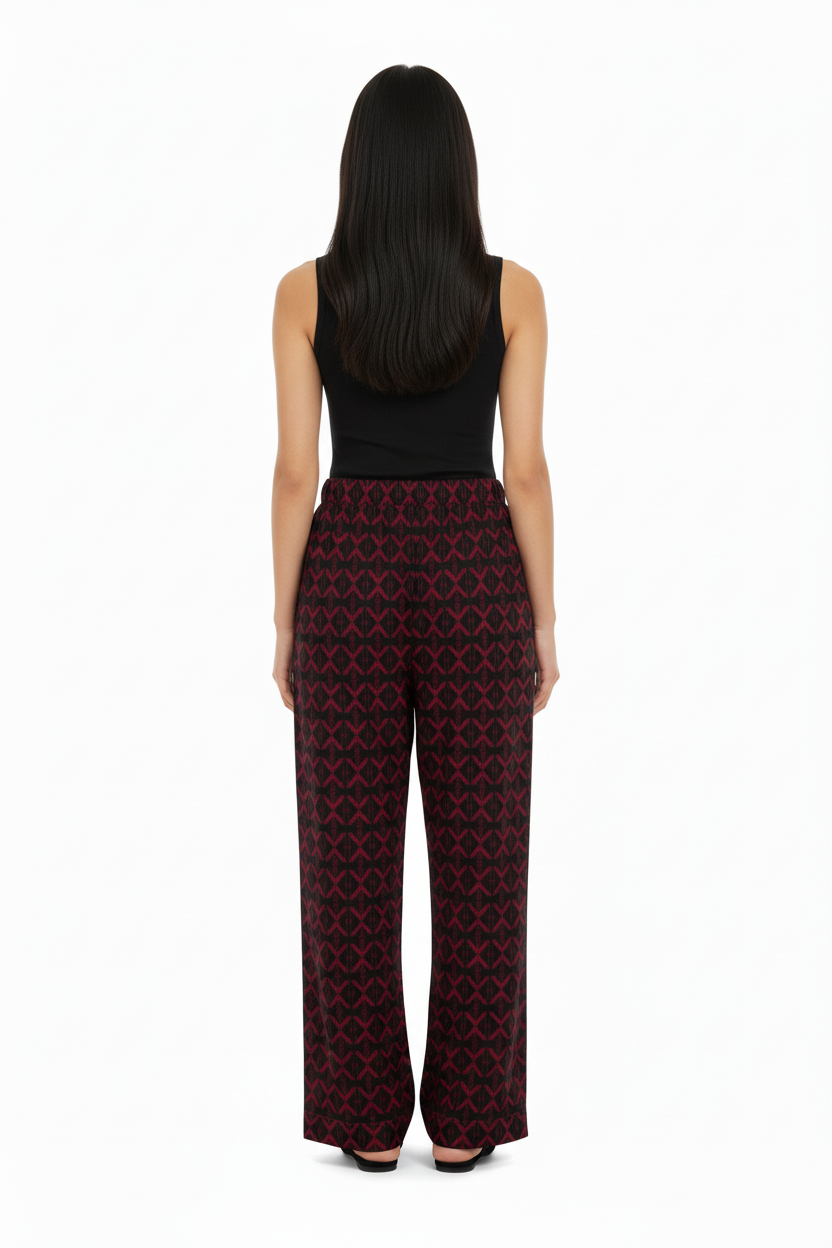 Back view of a model wearing NIMIAN Luxury Pyjama Trousers with a red geometric pattern
